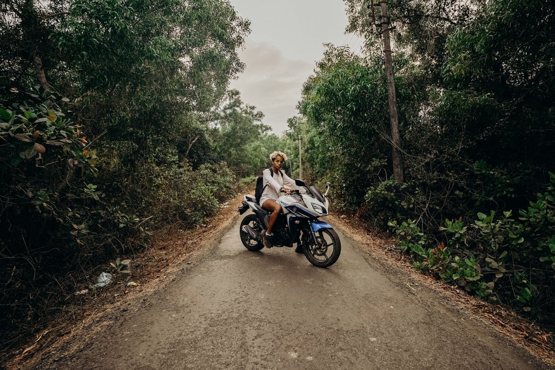 Man in Brown Jacket Riding Motorcycle on Dirt Road